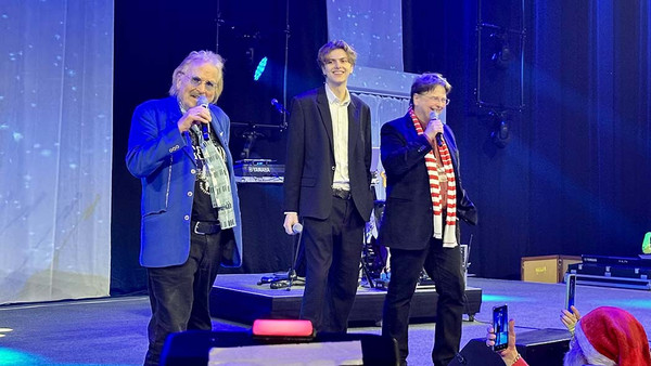 Drei Männer, alt, jung und mittelalt, auf einer Bühne.